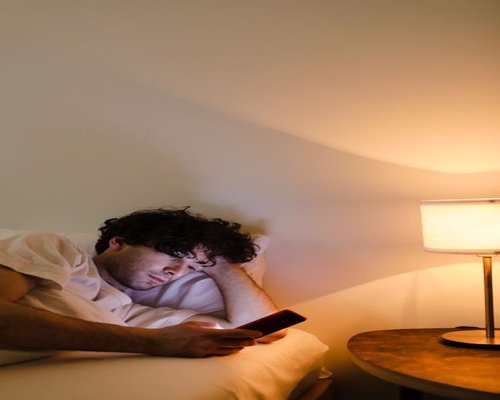 Someone checking phone at night in bed